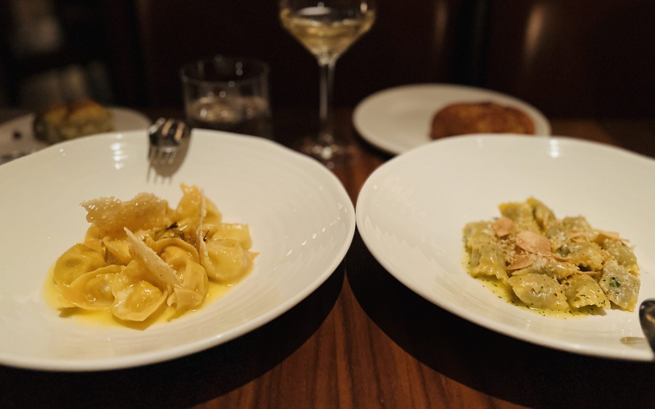 Plates of pasta dishes next to each other in a restaurant table.