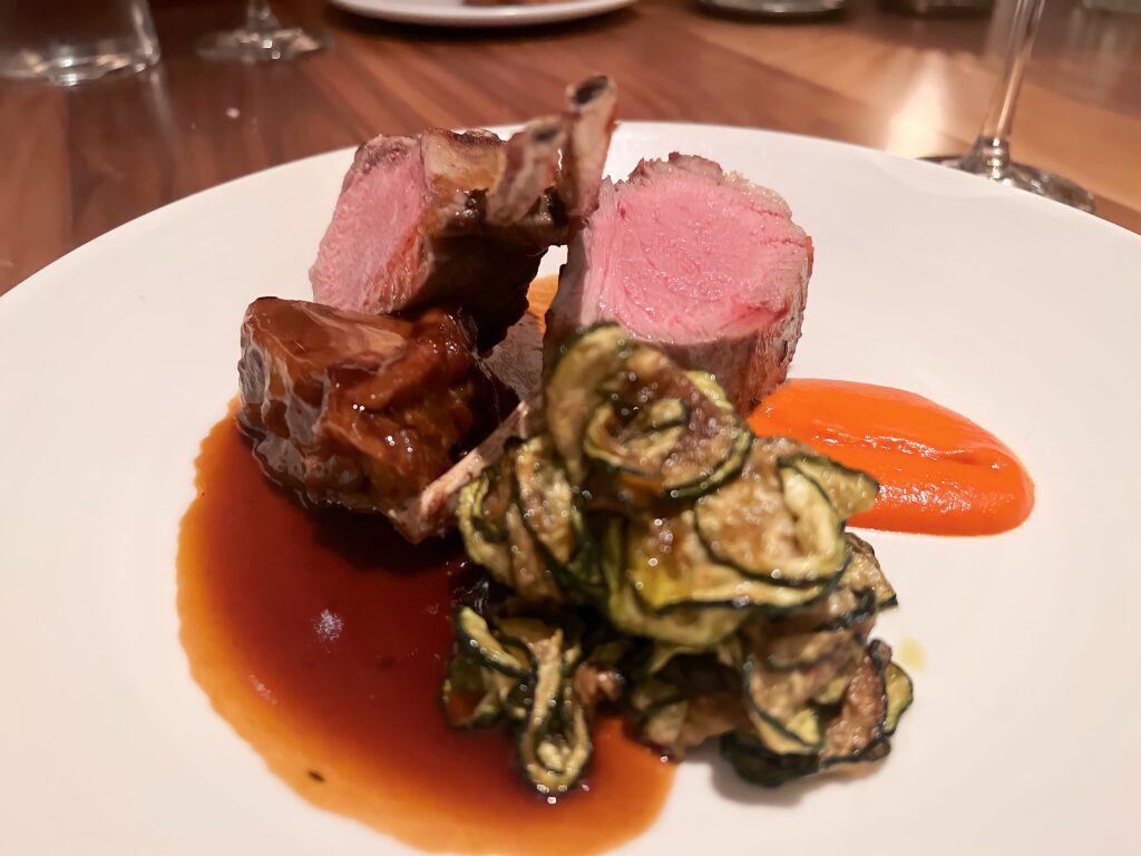 A meat main dish with pink lamb chops on a plate