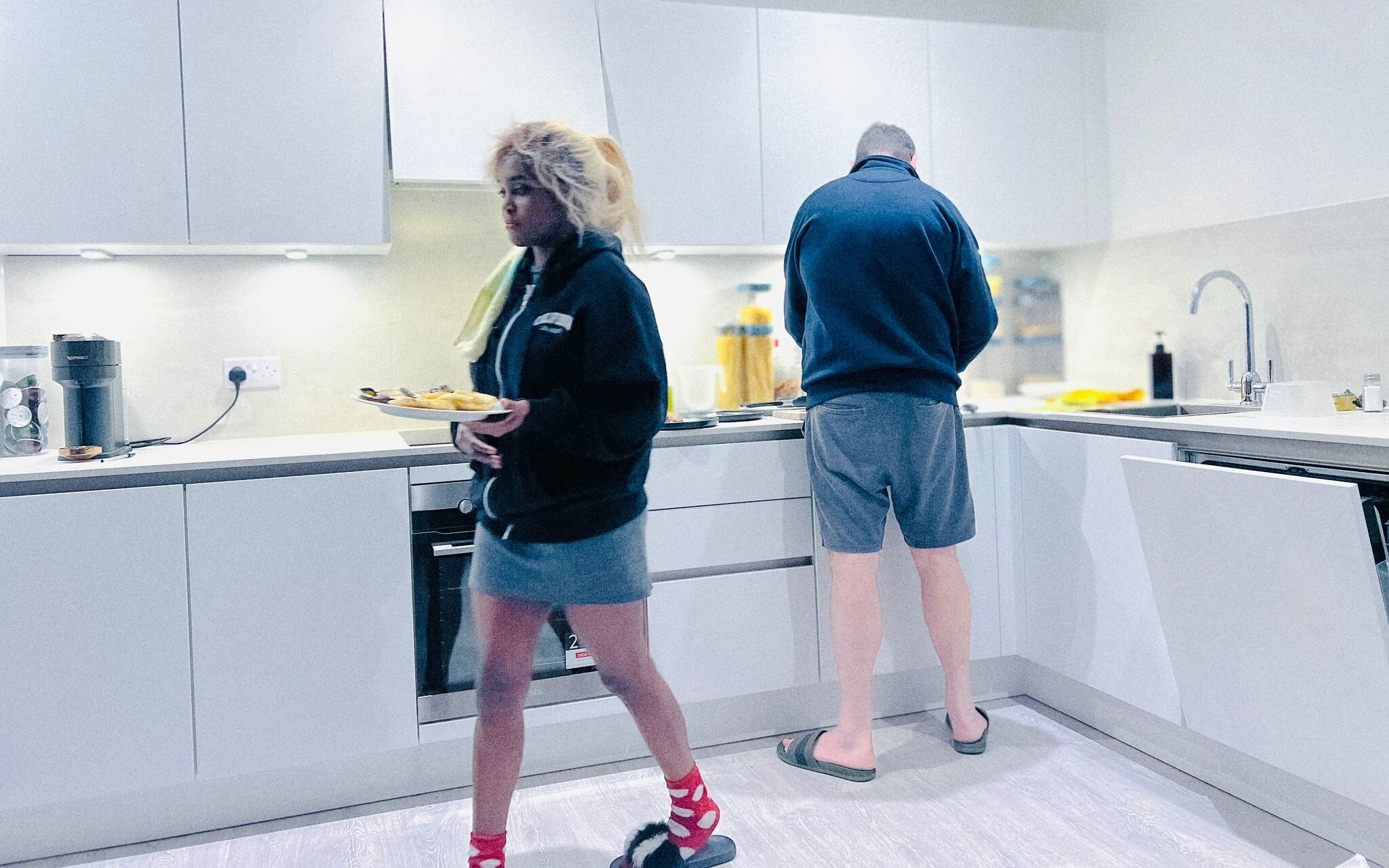 Female and male in kitchen cooking.