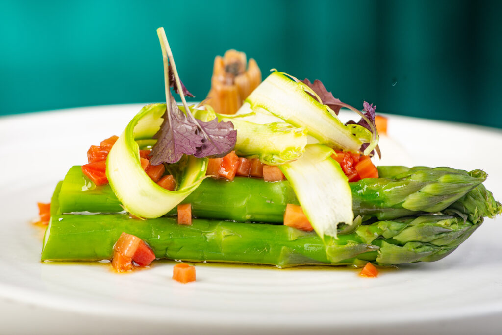 Fresh green asparagus spears neatly arranged on a clean white plate