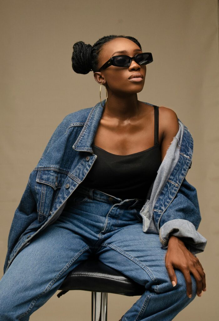 A girl wearing a denim on denim outfit featuring blue jeans and a matching blue denim coat.