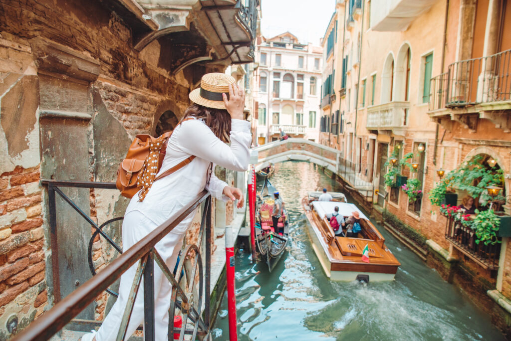 woman looking at canal with gondola while on vacation