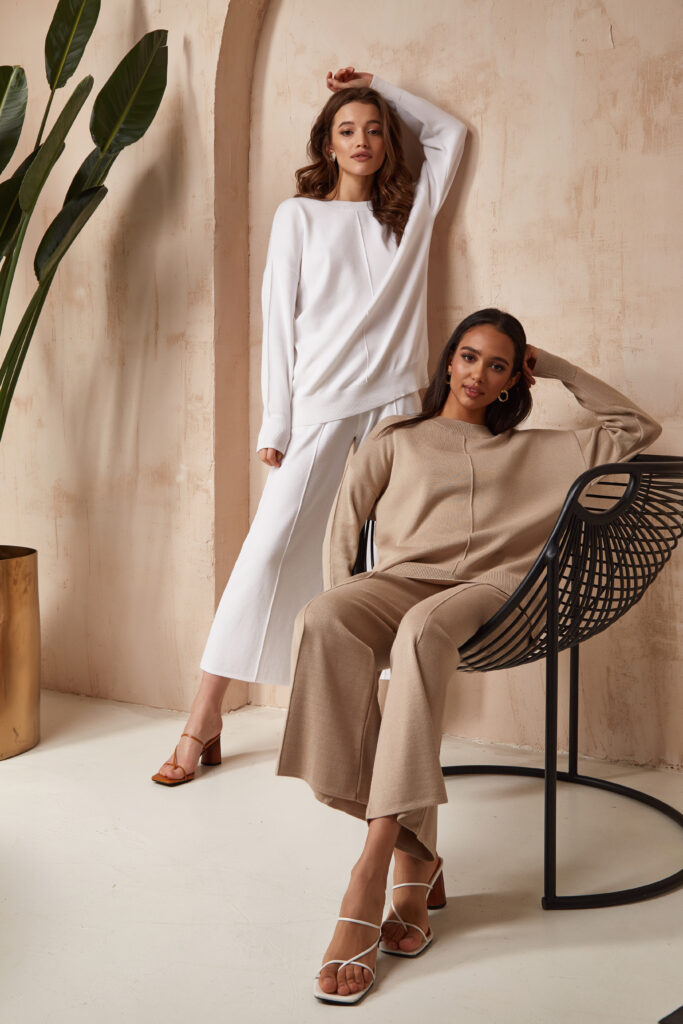 Two beautiful sexy brunette woman friends face cosmetic makeup tanned skin wear fashion clothes style beige white knitted suit sandals accessory interior furniture armchair journey summer flowerpot palm boho.