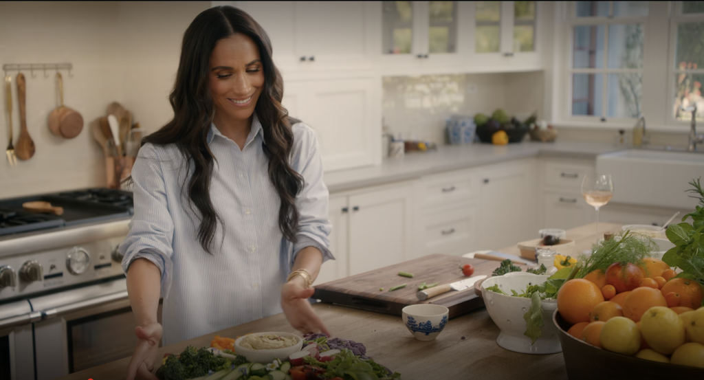 Meghan Markle presenting a beautifully arranged vegetable platter in her bright, elegant kitchen