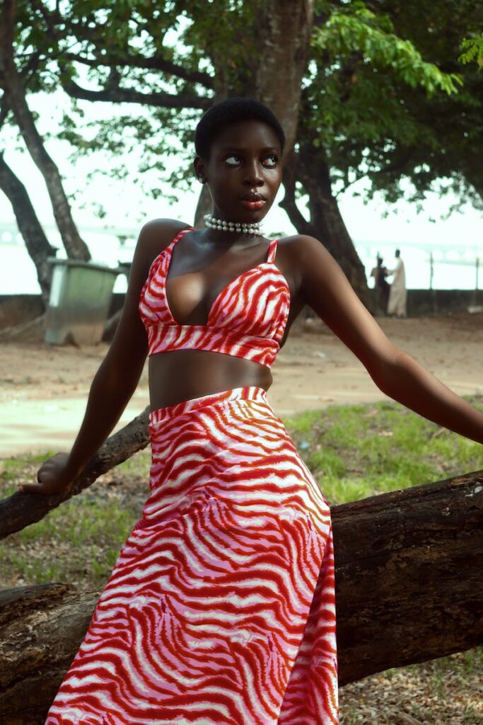 Woman in an African wildlife-inspired outfit dressed in zebra striped red crop top an skirt.