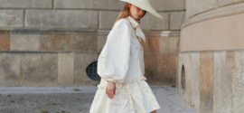 Woman in a white loose dress and matching wide brim hat - a stylish summer outfit