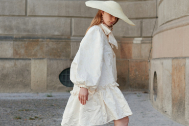 Woman in a white loose dress and matching wide brim hat - a stylish summer outfit