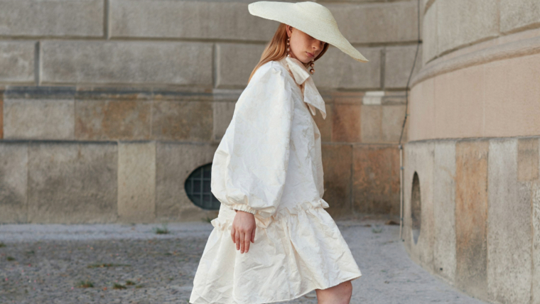 Woman in a white loose dress and matching wide brim hat - a stylish summer outfit