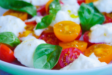 Close-up of Burrata Caprese made with creamy burrata, halved cherry tomatoes, and balsamic glaze. An easy no-cook Italian summer recipe.