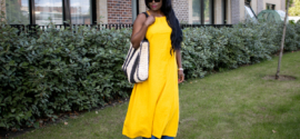 What to wear in Sub-Saharan Africa in July and August – woman in sunglasses wearing a yolk yellow linen dress over wide-leg blue jeans