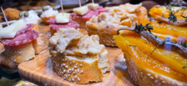 A diverse cicchetti platter on a rustic wooden board, showcasing various Venetian small tapas-like bites.