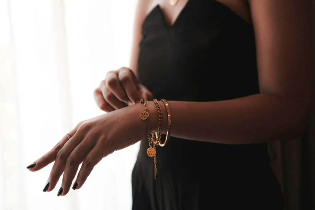 How to Accessorise an outfit: A woman wears three different bracelets on one wrist, illustrating the power of layering while keeping accessories thoughtfully edited.