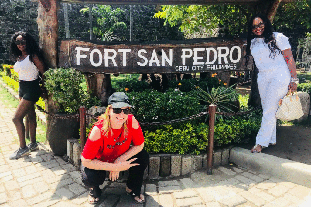 Three women posing at Fort San Pedro in Cebu, capturing a joyful moment of travelling abroad - even with a third world passport.