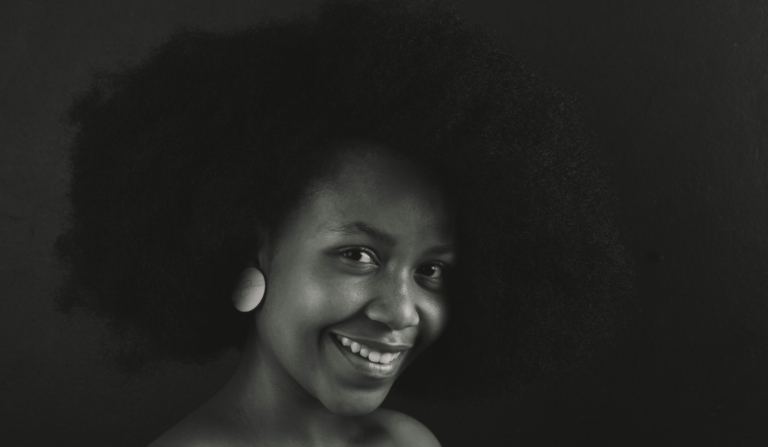 Black and white potrait photo of a black woman with a healthy Afro