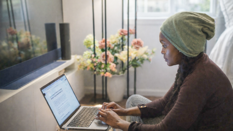 Woman working on a laptop at home, reflecting on a career change at 40