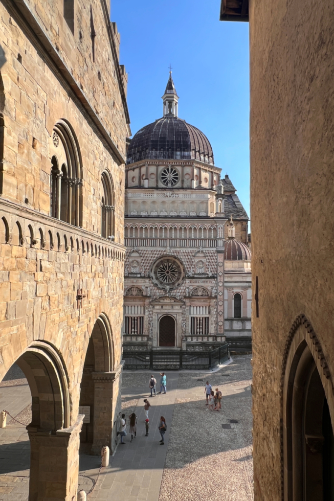 View of Bergamo’s Città Alta and historic cathedral courtyard, representing second city travel in Italy.