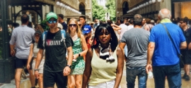 Woman walking through a busy Milan arcade surrounded by summer crowds, reflecting on the shift toward second city travel.