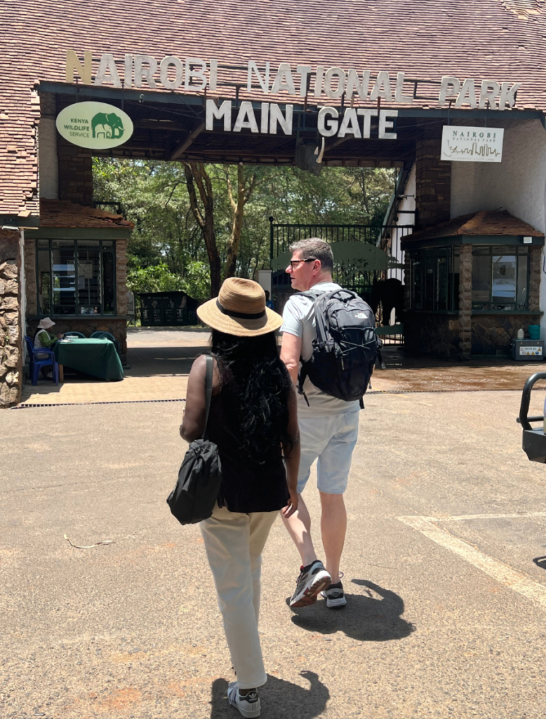 Two visitors walking toward the main gate of Nairobi National Park in Kenya.