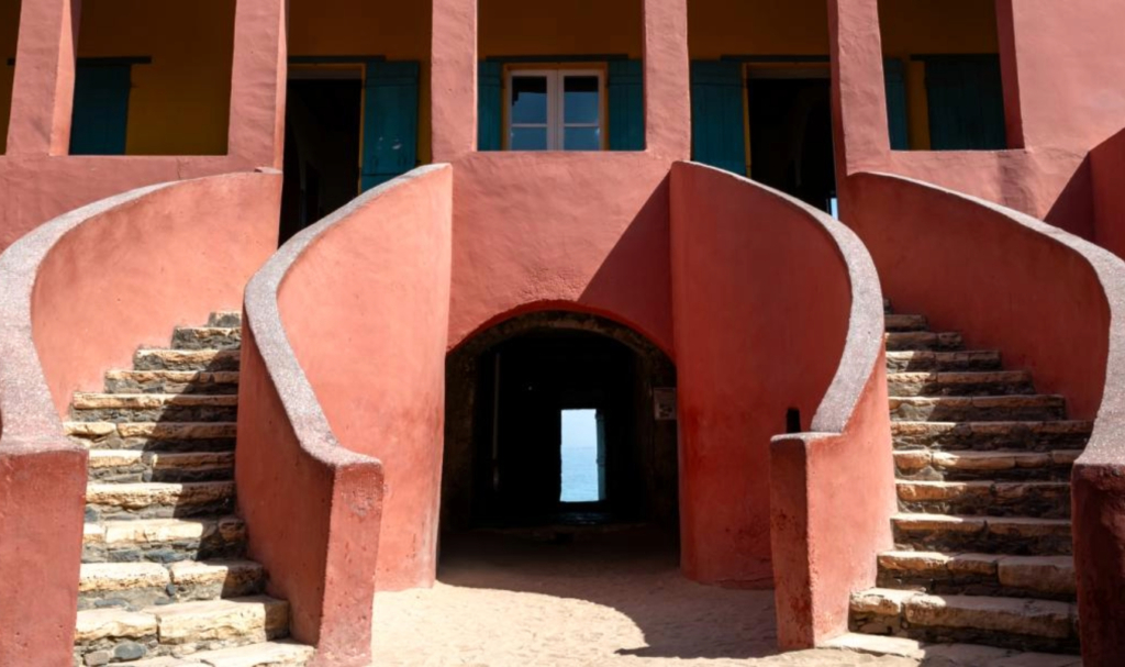Interior courtyard of the House of Slaves on Gorée Island Senegal with pink walls and curved staircases